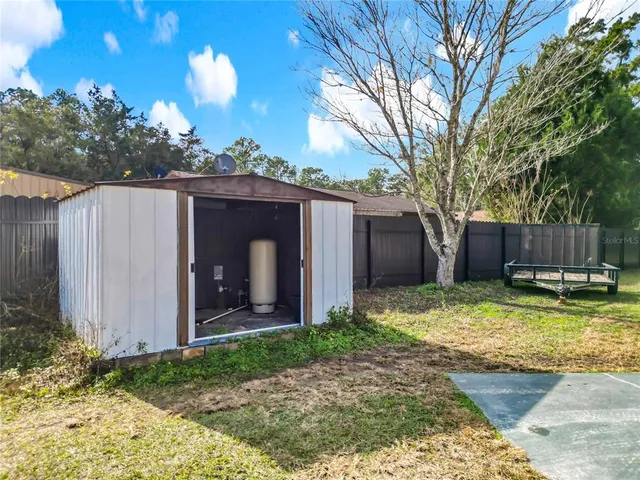 a room with water heater and wooden cabinets