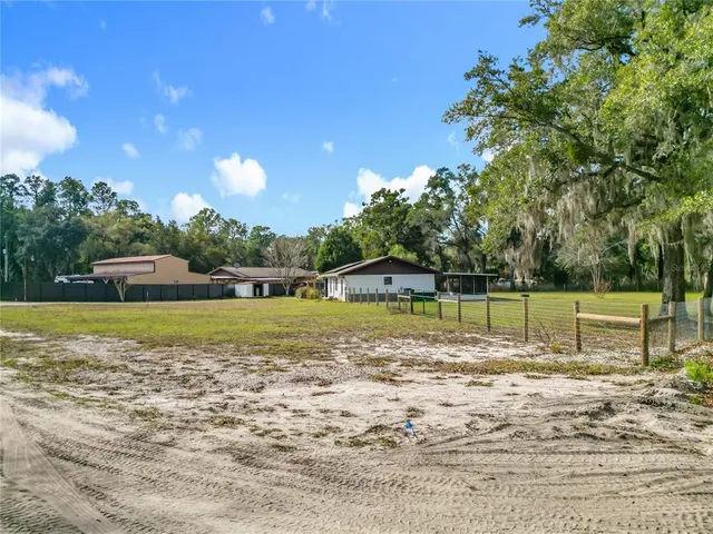 an aerial view of residential houses with outdoor space and trees