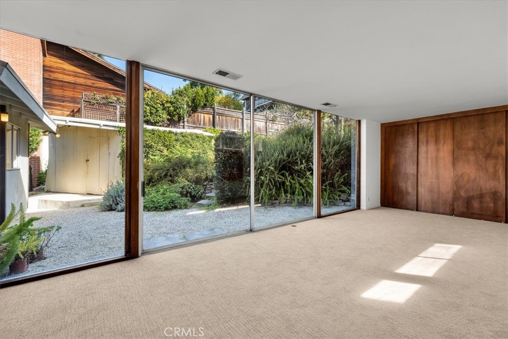 418 Sycamore Road Santa Monica, CA 90402 - Photo 7 of 43 a view of an empty room with floor to ceiling windows and wooden floor