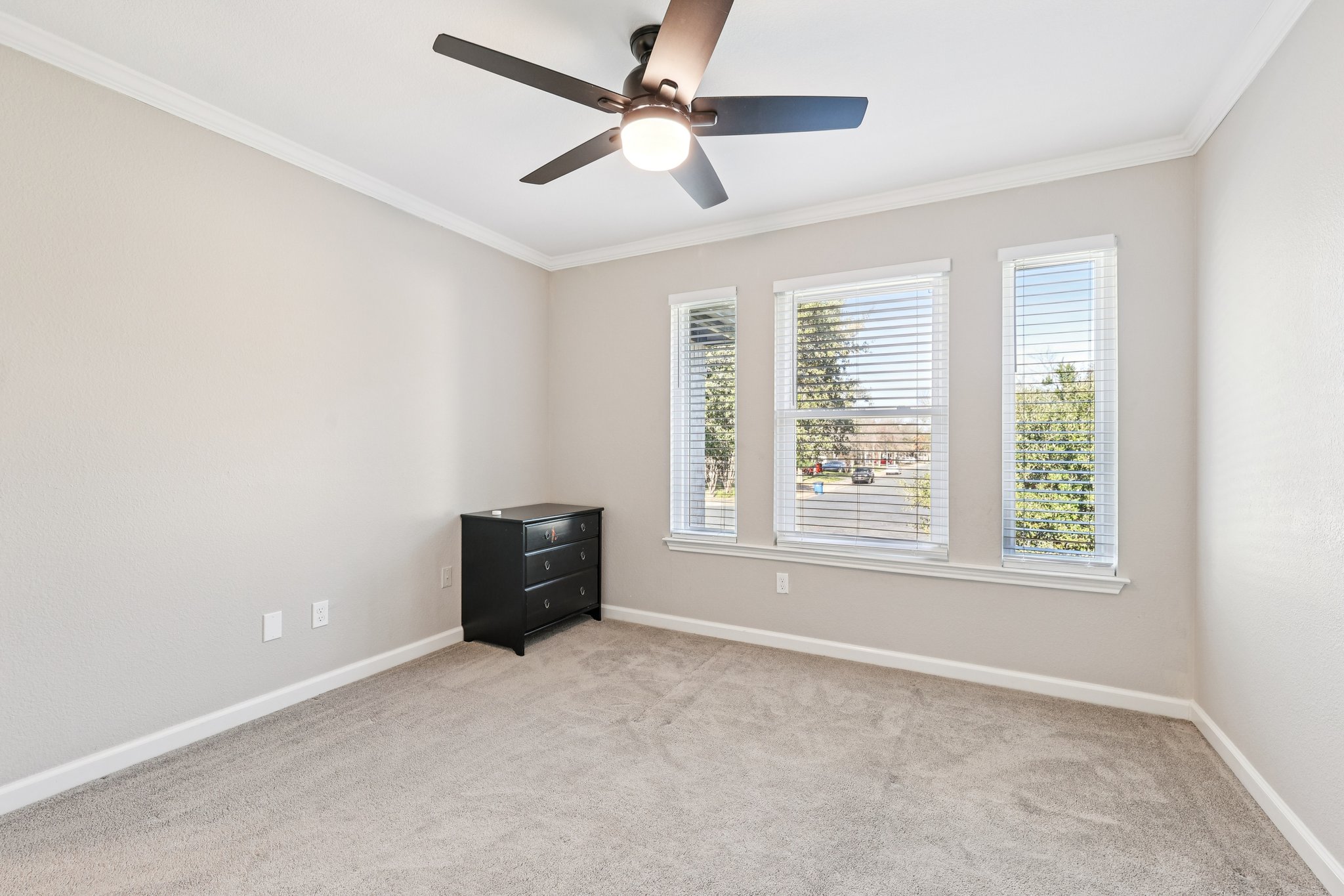 12717 Machete Trail Austin, TX 78729 - Photo 23 of 32 Empty room with crown molding, light carpet, and ceiling fan