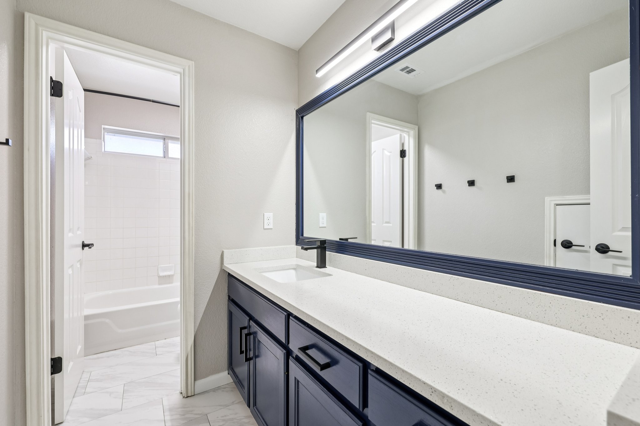 12717 Machete Trail Austin, TX 78729 - Photo 24 of 32 Bathroom featuring vanity, shower / bath combination, and light marble finish flooring