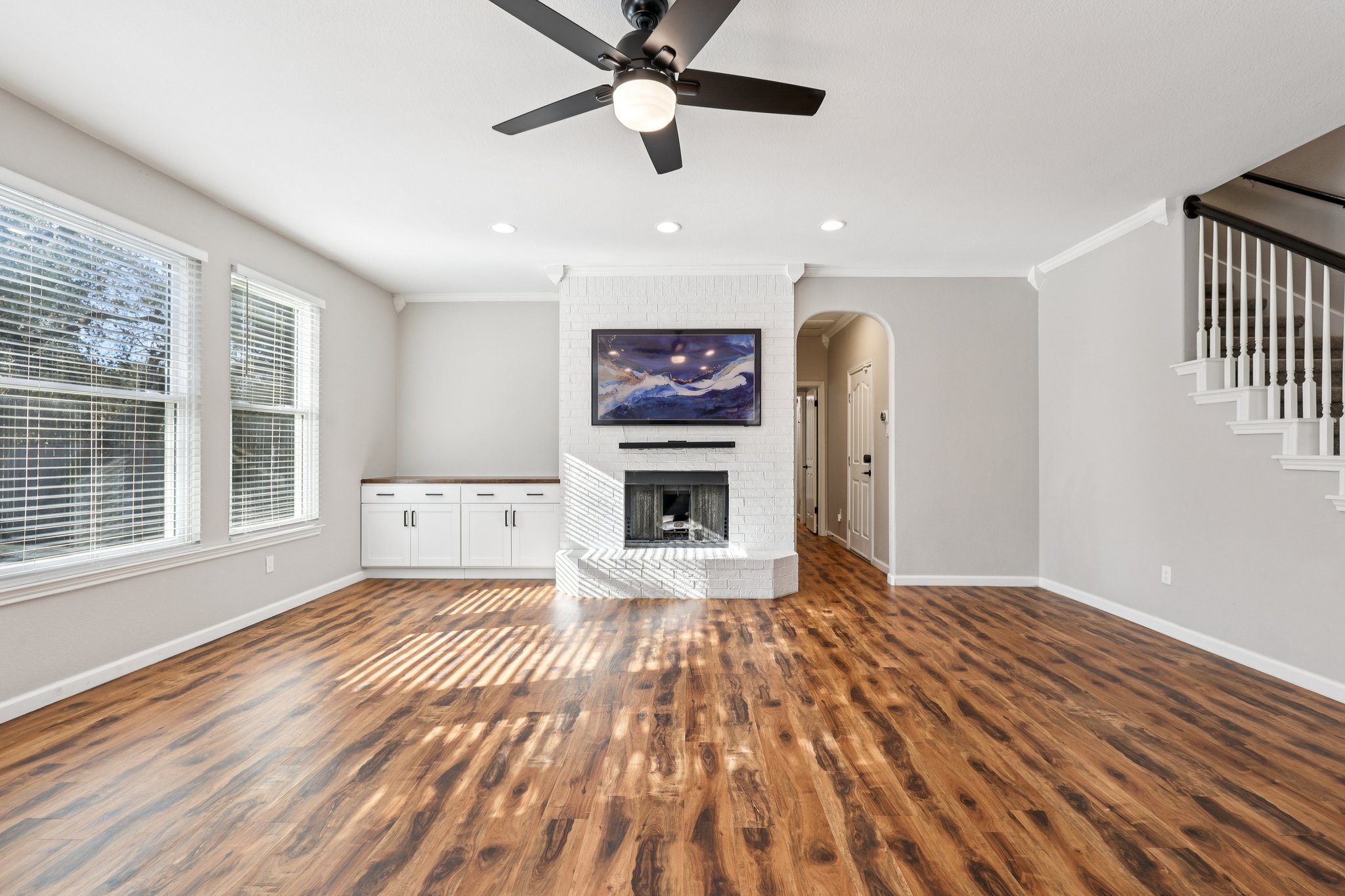12717 Machete Trail Austin, TX 78729 - Photo 5 of 32 Unfurnished living room featuring a fireplace, dark wood-style flooring, a ceiling fan, ornamental molding, and recessed lighting