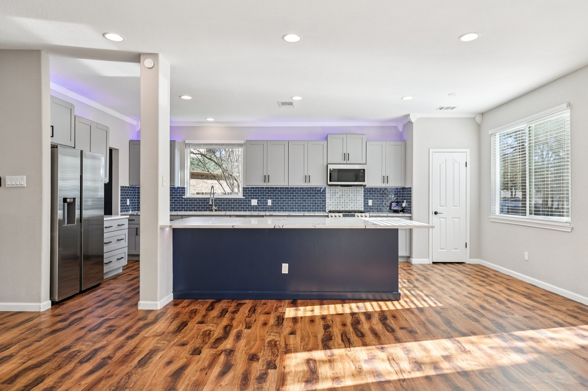 12717 Machete Trail Austin, TX 78729 - Photo 8 of 32 Kitchen featuring gray cabinets, stainless steel fridge with ice dispenser, dark wood-style floors, ornamental molding, and backsplash