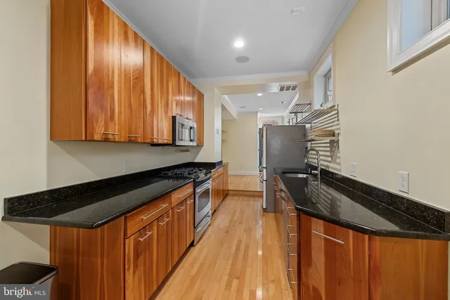 a kitchen with granite countertop a stove and a sink
