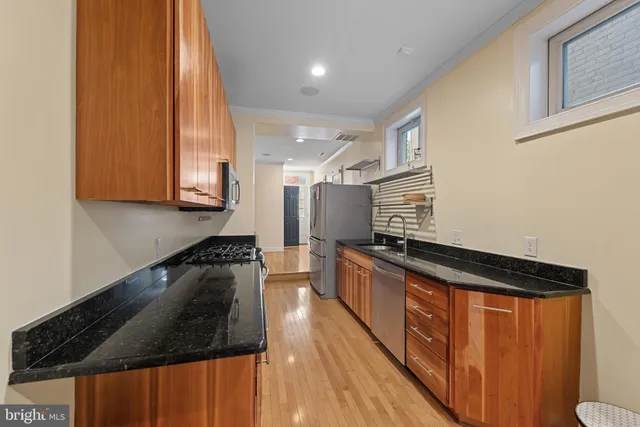 a kitchen with granite countertop a sink a stove and cabinets