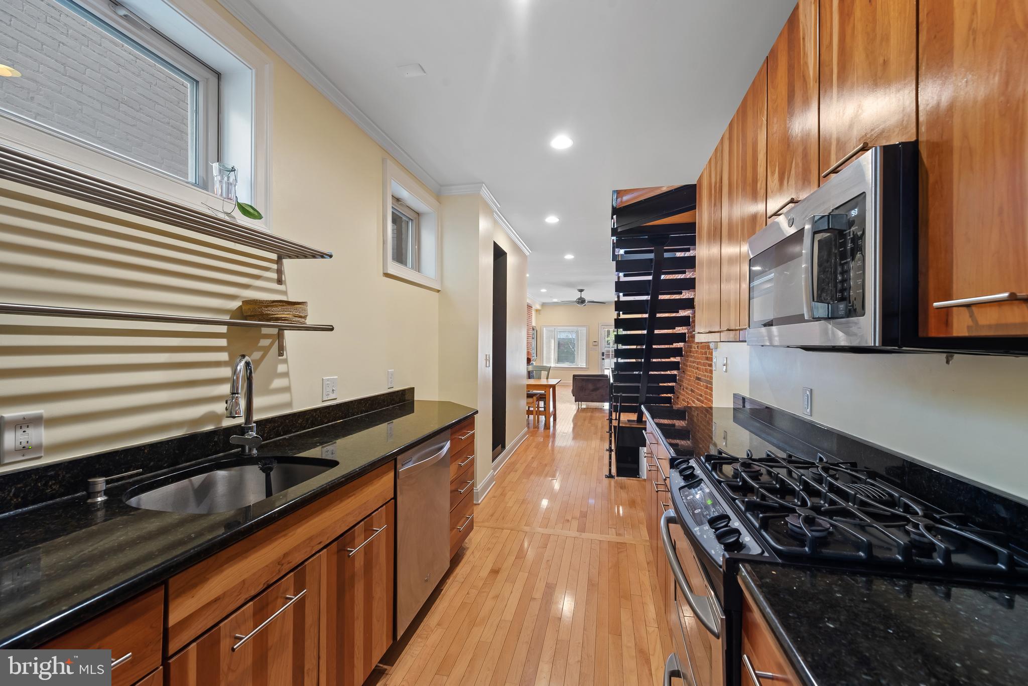 3006 Dillon Street Baltimore, MD 21224 - Photo 10 of 27 a kitchen with granite countertop stainless steel appliances and wooden floor