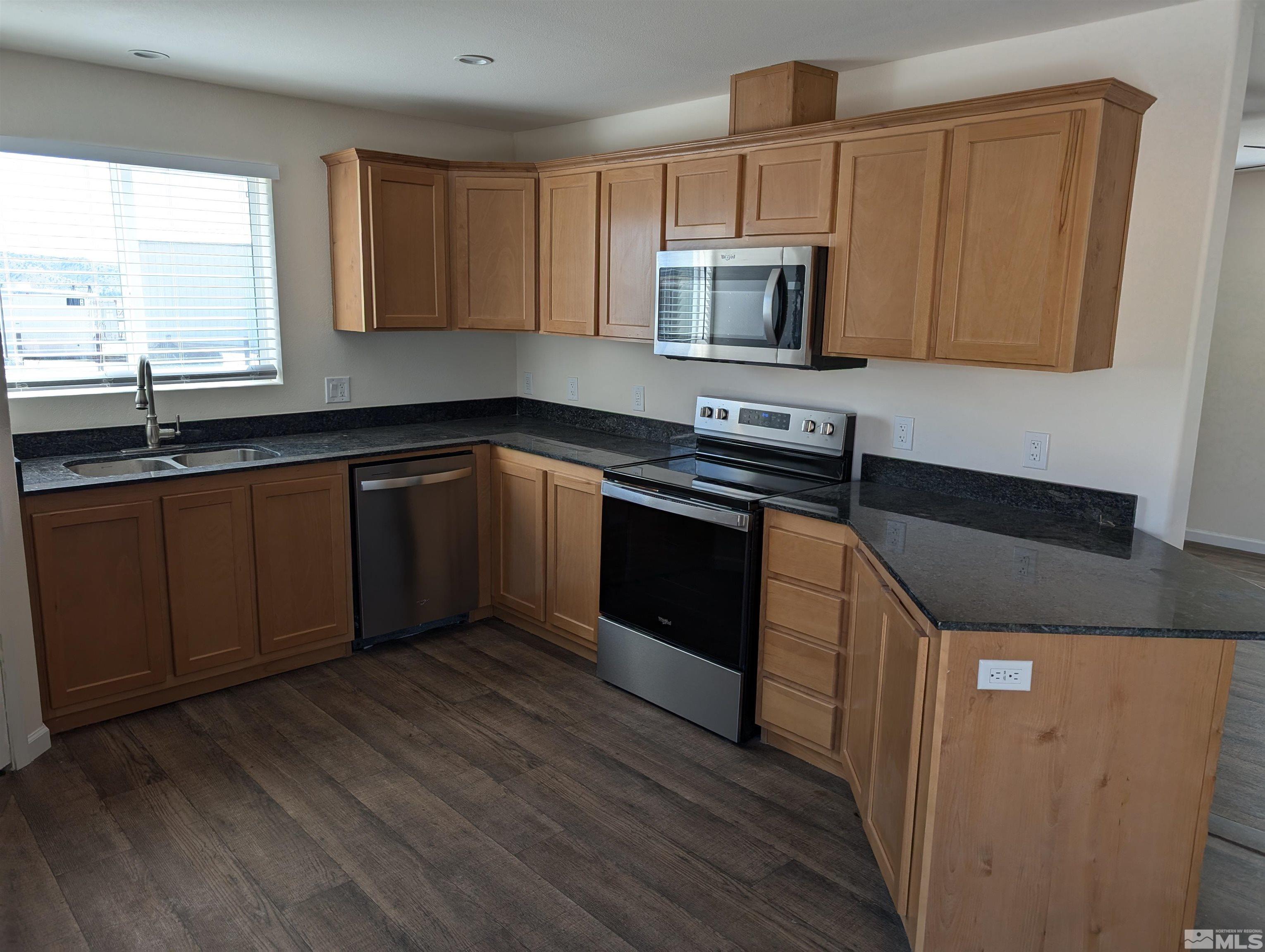 520 Matterhorn Boulevard Reno, NV 89506 - Photo 8 of 11 a kitchen with stainless steel appliances kitchen island granite countertop a sink and a stove top oven