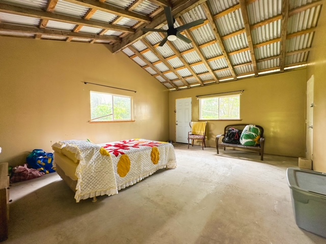 11-3239 4th Street Volcano, HI 96785 - Photo 8 of 22 a spacious bedroom with a bed and a chandelier