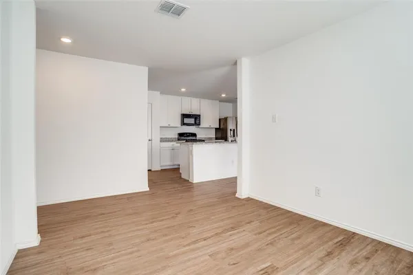 a view of a kitchen with wooden floor and a sink