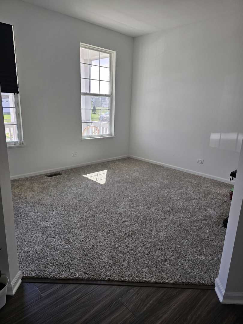 81 Sweetflag Circle Elgin, IL 60124 - Photo 5 of 9 a view of an empty room with wooden floor and a window