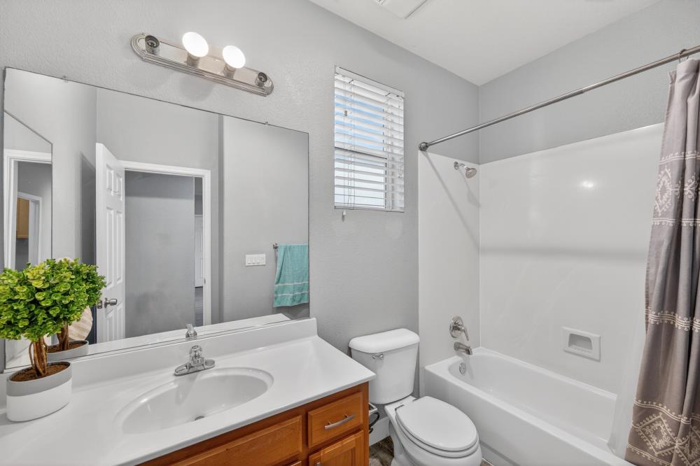 3045 Delta Tule Way Sacramento, CA 95834 - Photo 23 of 65 a bathroom with a sink a toilet a mirror and shower