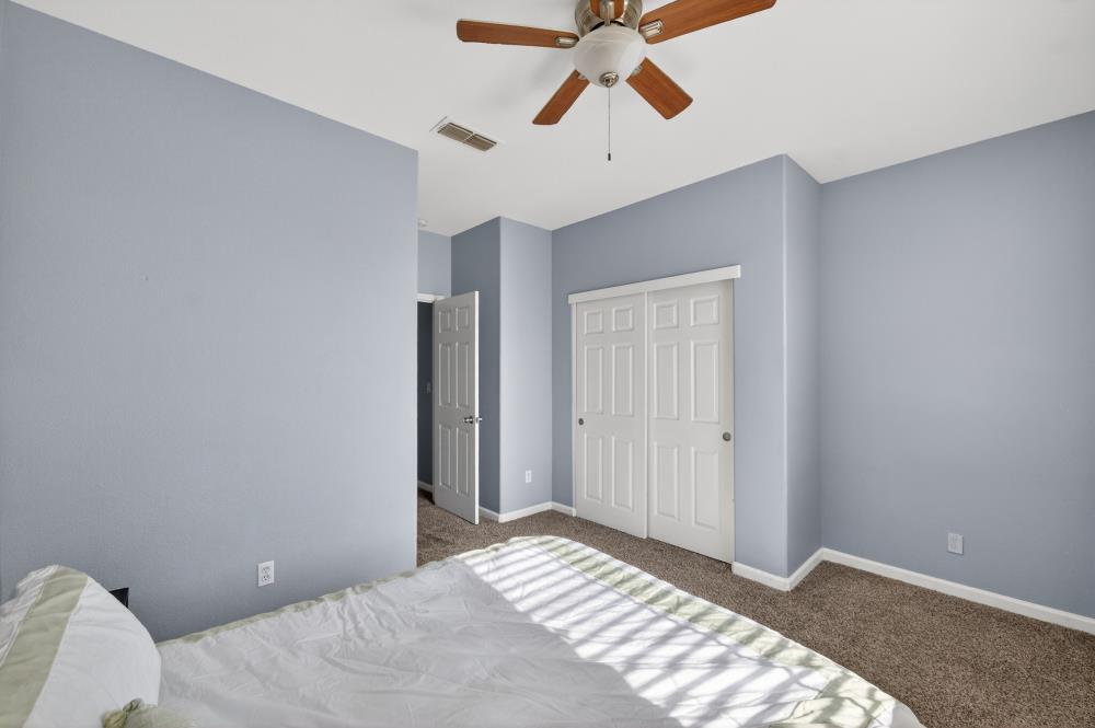 3045 Delta Tule Way Sacramento, CA 95834 - Photo 49 of 65 a bedroom with a bed and a chandelier