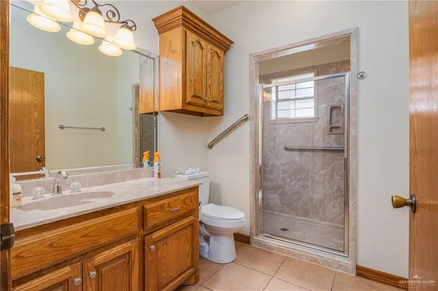 a bathroom with a granite countertop sink a toilet and shower