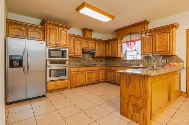 a kitchen with stainless steel appliances a refrigerator sink and microwave