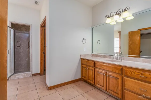 a spacious bathroom with a granite countertop sink a mirror and a shower