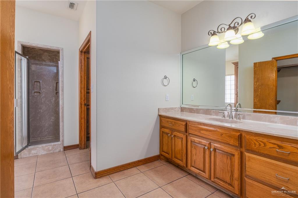 738 County Road 137 Alice, TX 78332 - Photo 9 of 33 a spacious bathroom with a granite countertop sink a mirror and a shower