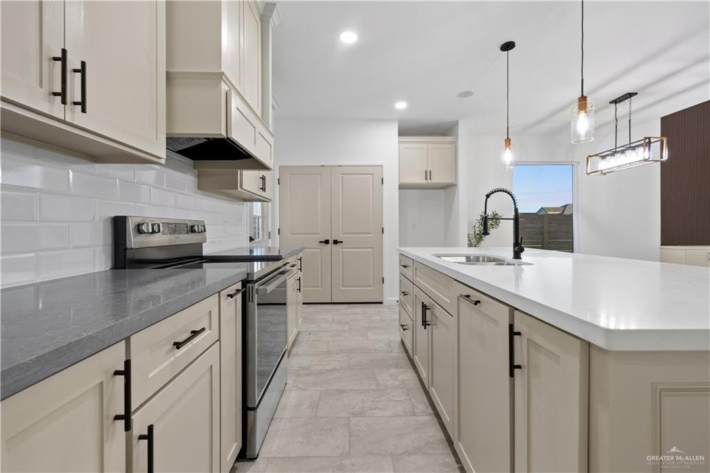 2713 East Comal Road Edinburg, TX 78542 - Photo 12 of 29 a kitchen with stainless steel appliances a sink a stove and a wooden floors