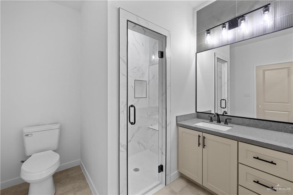 2713 East Comal Road Edinburg, TX 78542 - Photo 14 of 29 a bathroom with a granite countertop sink toilet and shower