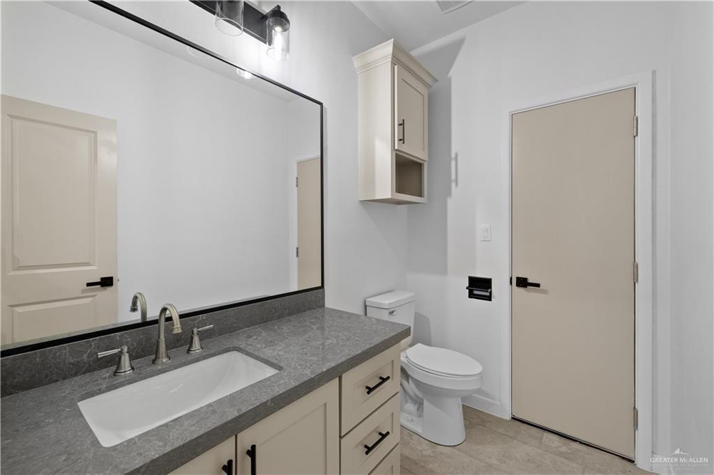 2713 East Comal Road Edinburg, TX 78542 - Photo 24 of 29 a bathroom with a granite countertop sink toilet a mirror and shower