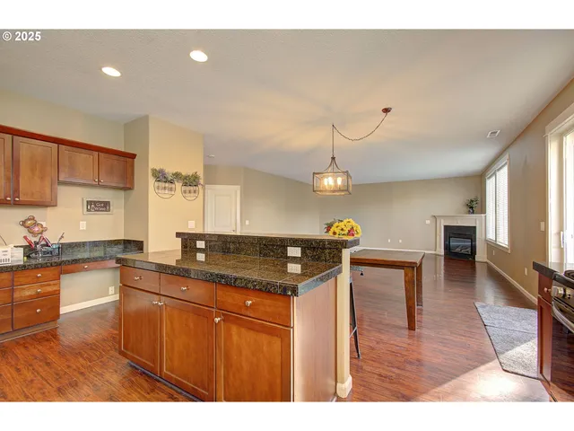 a kitchen with granite countertop a stove a sink dishwasher and a refrigerator