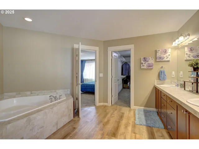 a bathroom with a tub sink and mirror