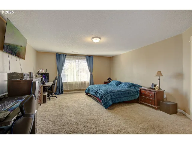 a bedroom with furniture and a flat screen tv