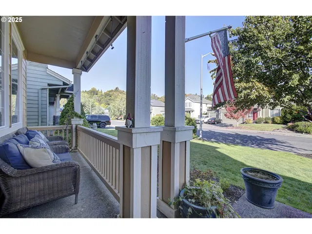 a balcony with chairs and a potted plant