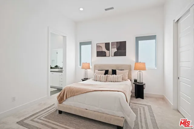 a spacious bedroom with a bed and a large window