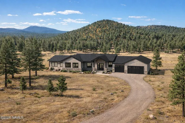 a view of a large house with a big yard and large tree
