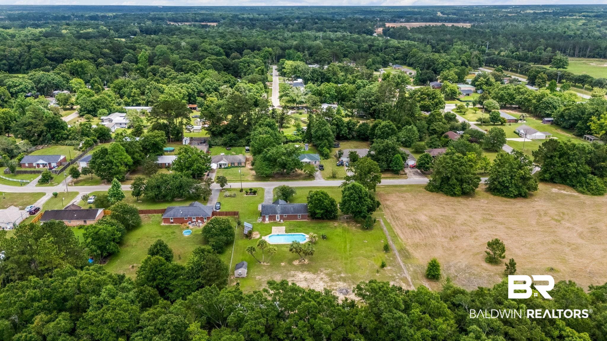 15096 Highland Circle Foley, AL 36535 - Photo 39 of 52 Aerial perspective showcasing a property with a swimming pool, surrounded by mature trees and residential homes