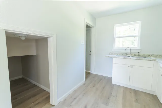 a room with a sink cabinets and a window
