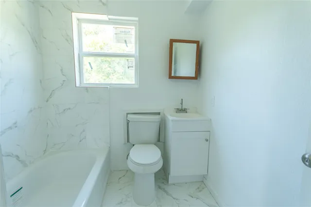 a bathroom with a toilet a sink and a window