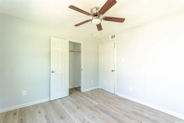 a view of an empty room with a ceiling fan