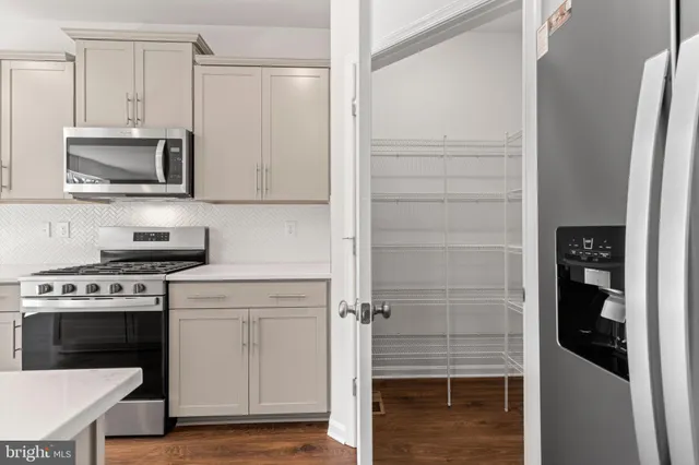 a kitchen with stainless steel appliances white cabinets and a stove top oven