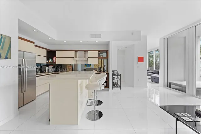 a kitchen with stainless steel appliances kitchen island granite countertop a refrigerator and cabinets