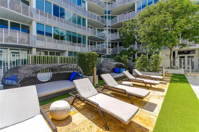 a view of a patio with couches table and chairs and potted plants