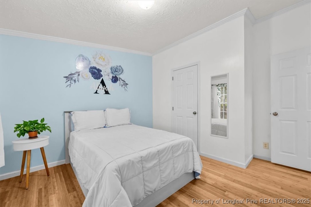 11891 Aberdeen Road Aberdeen, NC 28315 - Photo 17 of 35 a spacious bedroom with a bed and a painting on the wall