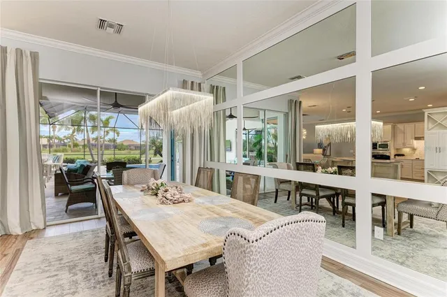 a dining room with furniture a large window and wooden floor