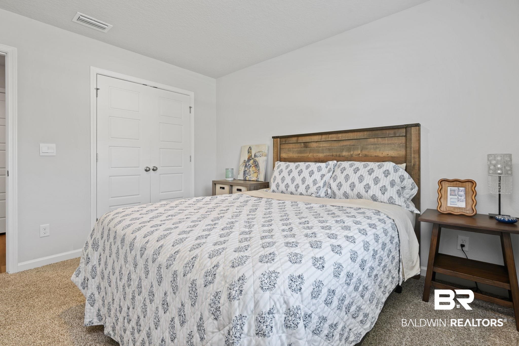 8021 Valor Rdg Way North Mobile, AL 36619 - Photo 18 of 34 Carpeted room with a rustic wood headboard, white walls, and a multi-panel closet door