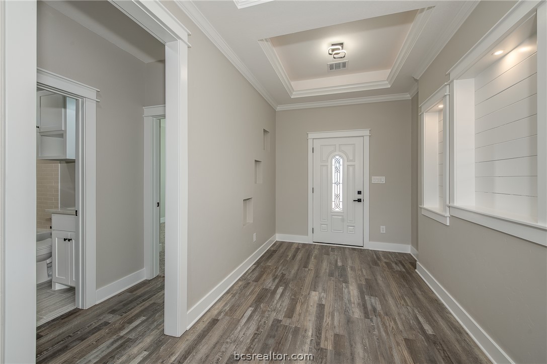 2908 GOLDBERG Drive Bryan, TX 77808 - Photo 7 of 44 View of the front door, decorative art niches, board and batten boards, pop up ceilings and vinyl flooring.