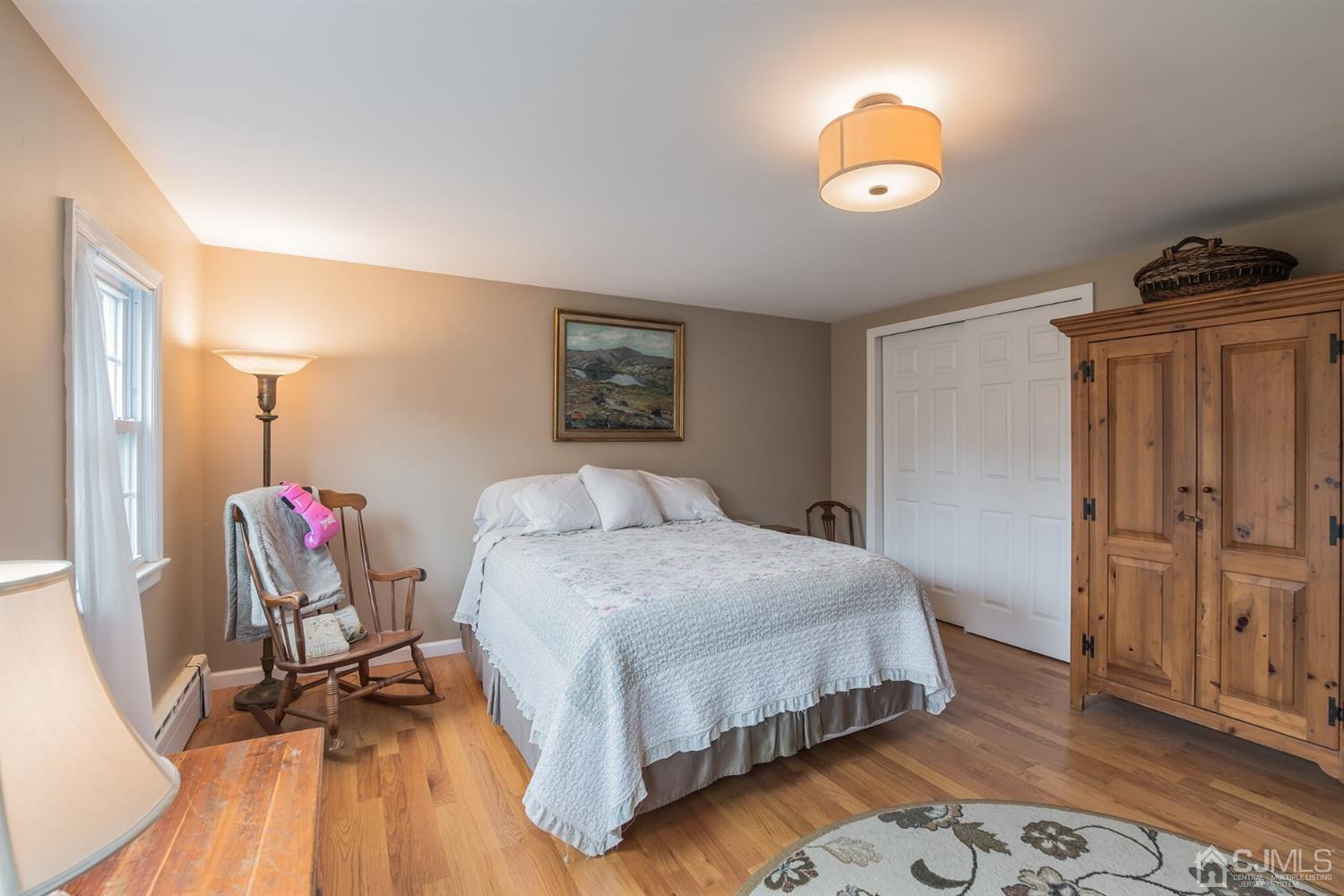 11 Station Road Cranbury, NJ 08512 - Photo 19 of 26 a bedroom with a bed and wooden floor