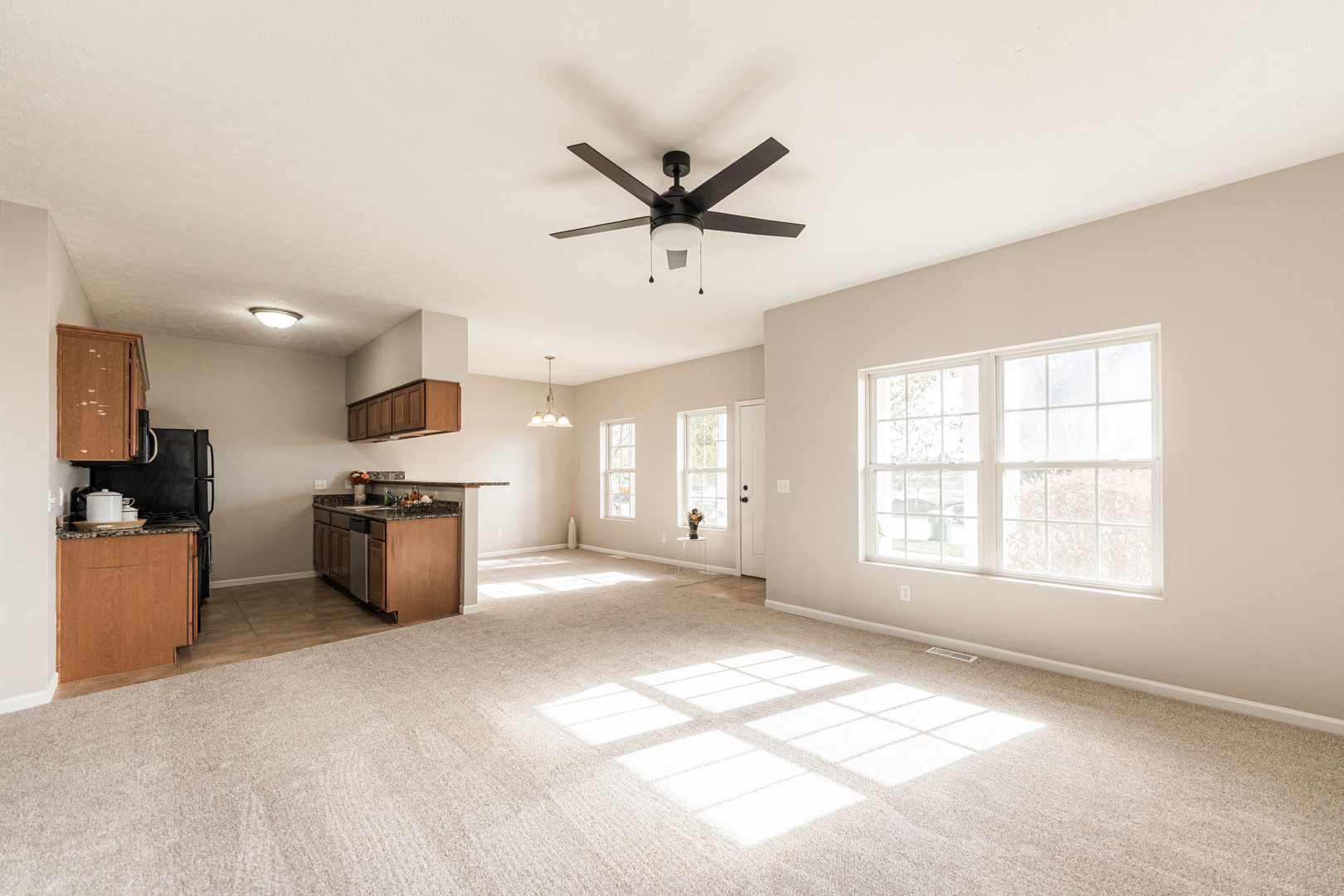 639 Stonegate Drive Sycamore, IL 60178 - Photo 11 of 32 a view of a kitchen with a stove cabinets a ceiling fan and wooden floor