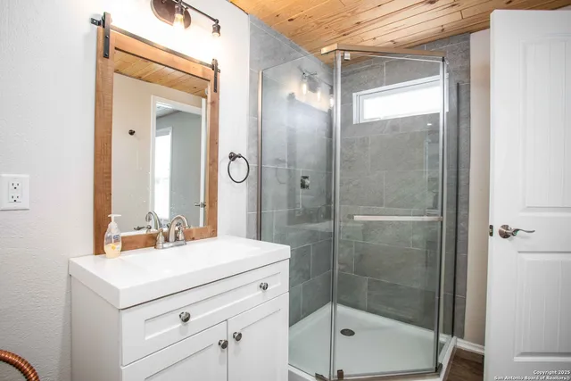 a bathroom with a shower sink and mirror