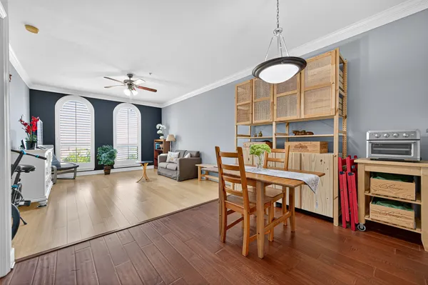 a view of a dining room with furniture a chandelier and wooden floor