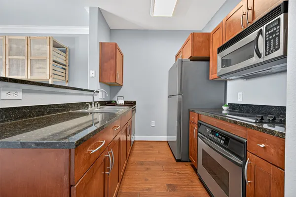 a kitchen with stainless steel appliances granite countertop a stove and a microwave