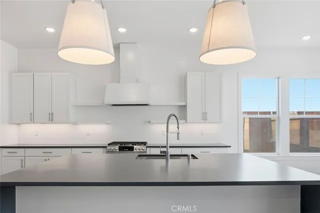 a kitchen with kitchen island a large counter top a sink a stove and a refrigerator