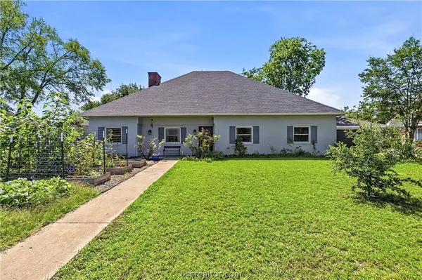 a view of a house with a yard and potted plants