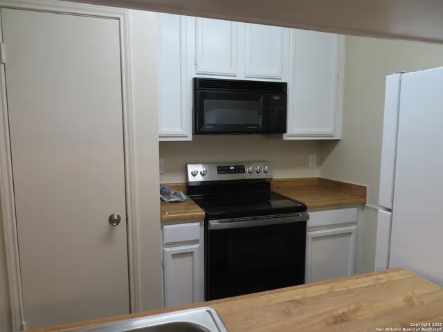 a kitchen with stainless steel appliances granite countertop a sink and a refrigerator