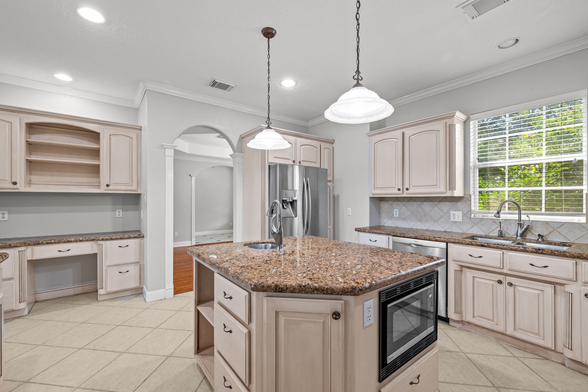 6410 Old Chocolate Bayou Road Manvel, TX 77578 - Photo 11 of 49 This spacious kitchen features
granite countertops, a large
island, stainless steel
appliances, and ample cabinetry.
The room is well-lit with natural
light and has a modern, open
layout with elegant archways.