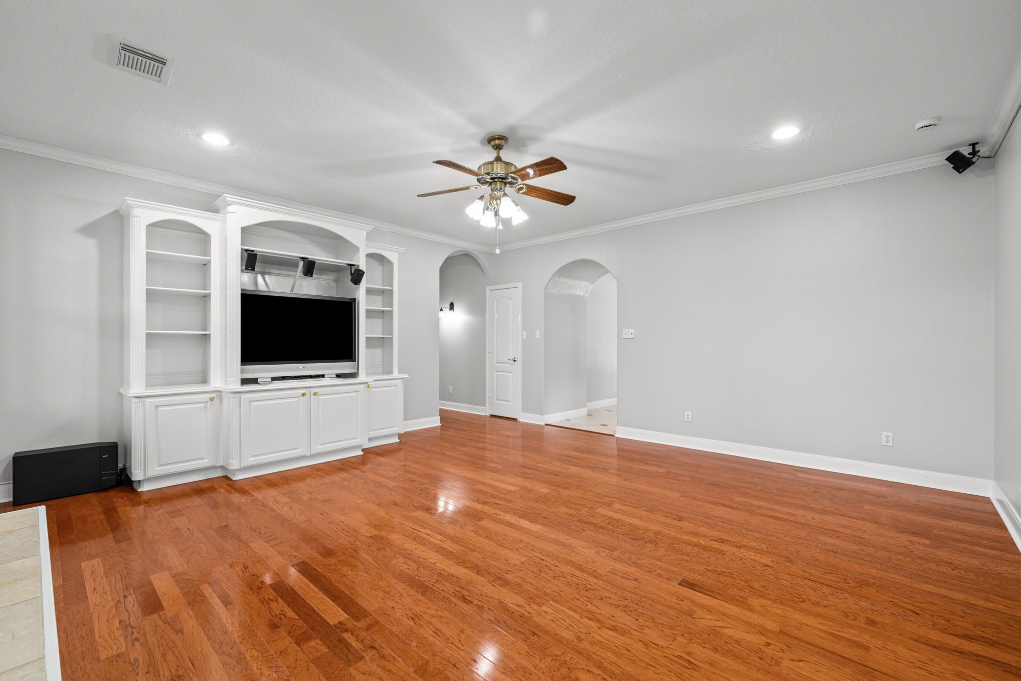 6410 Old Chocolate Bayou Road Manvel, TX 77578 - Photo 16 of 49 Spacious living room with
elegant hardwood floors, custom
built-in shelving, and surround
sound speakers perfect for
relaxing or entertaining